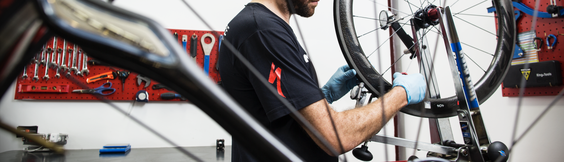 Um homem está trabalhando em uma roda de bicicleta em uma garagem.