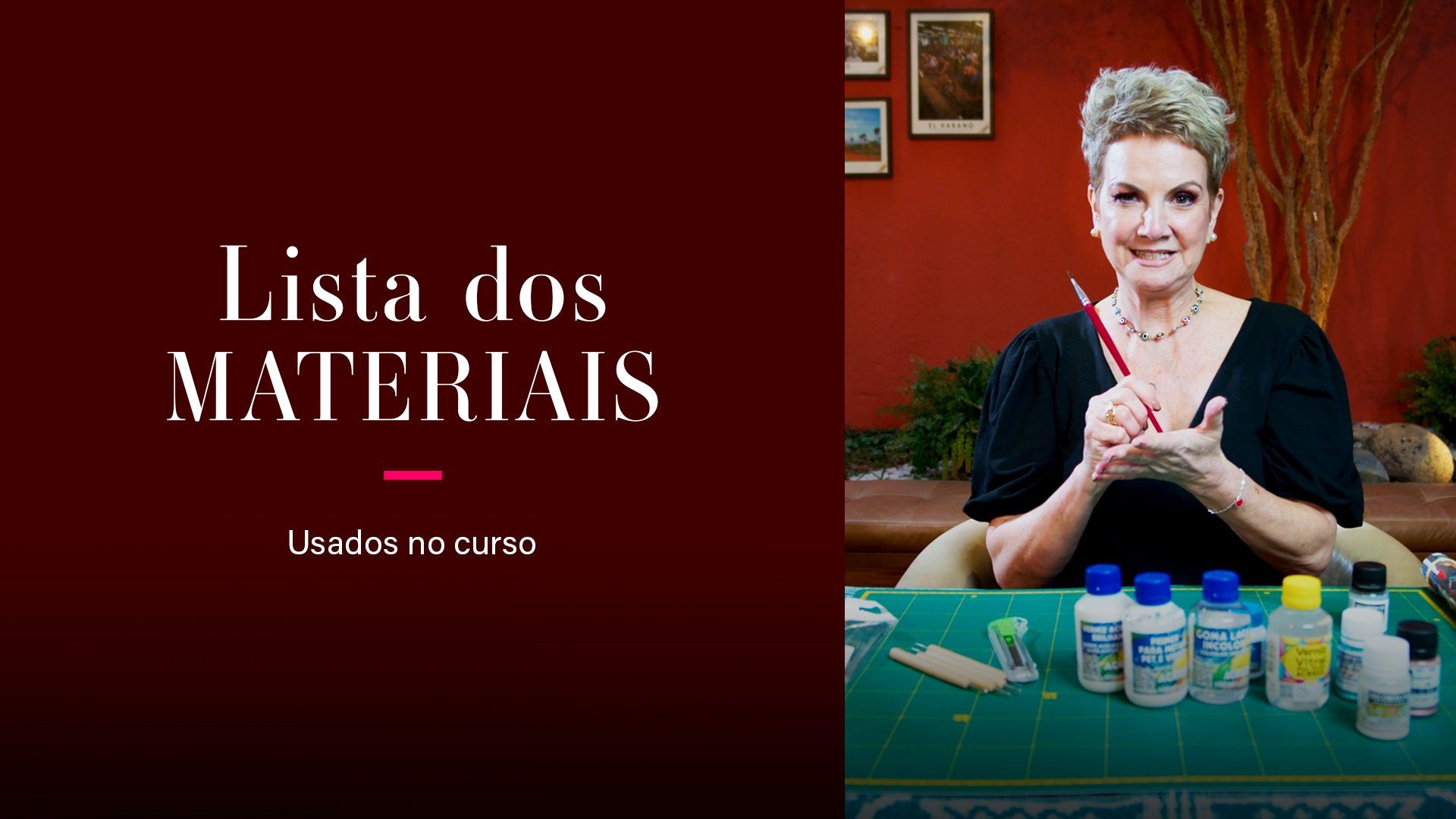 Uma mulher está sentada a uma mesa com frascos de tinta.