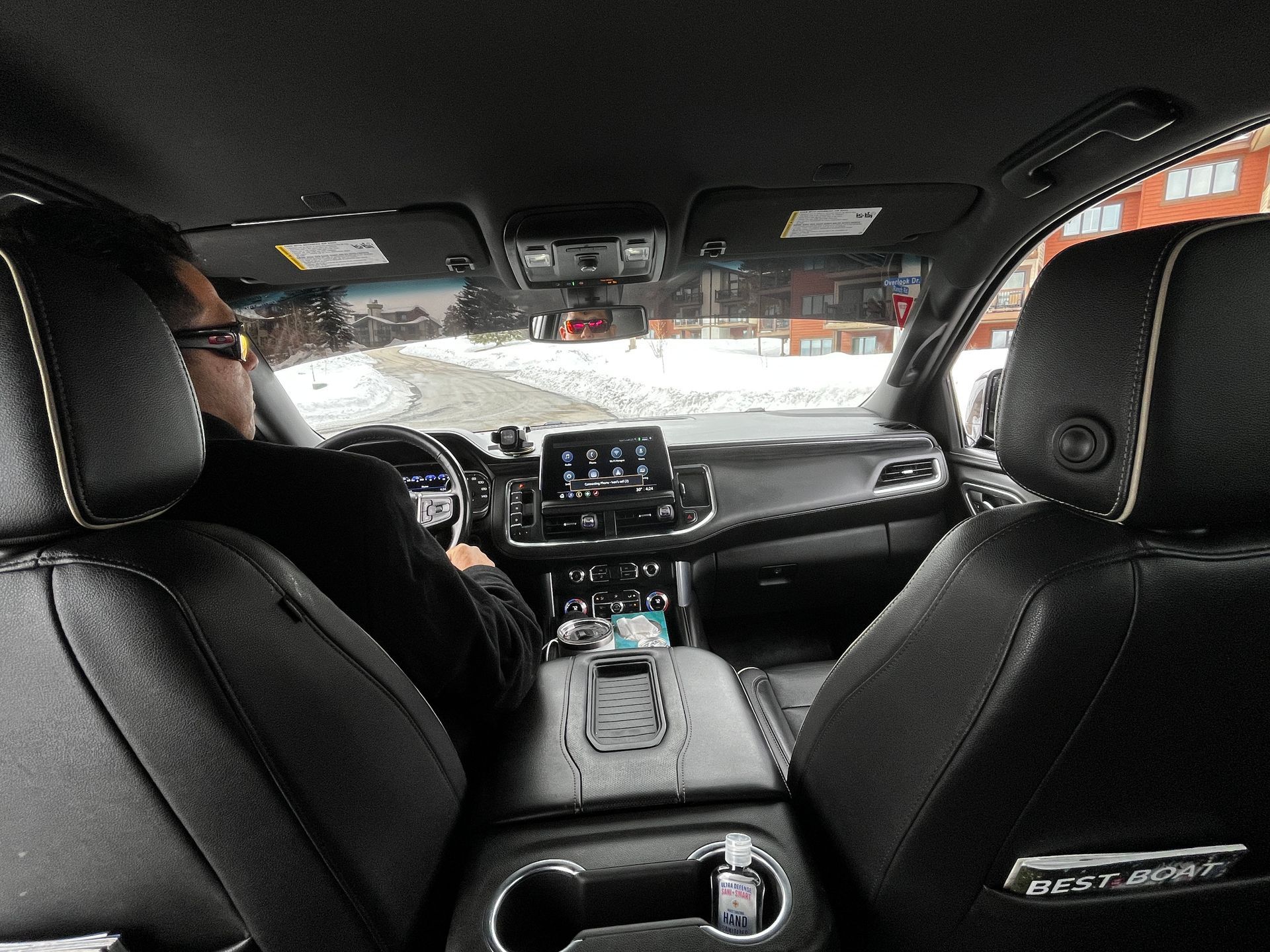 A man is sitting in the driver 's seat of a car.
