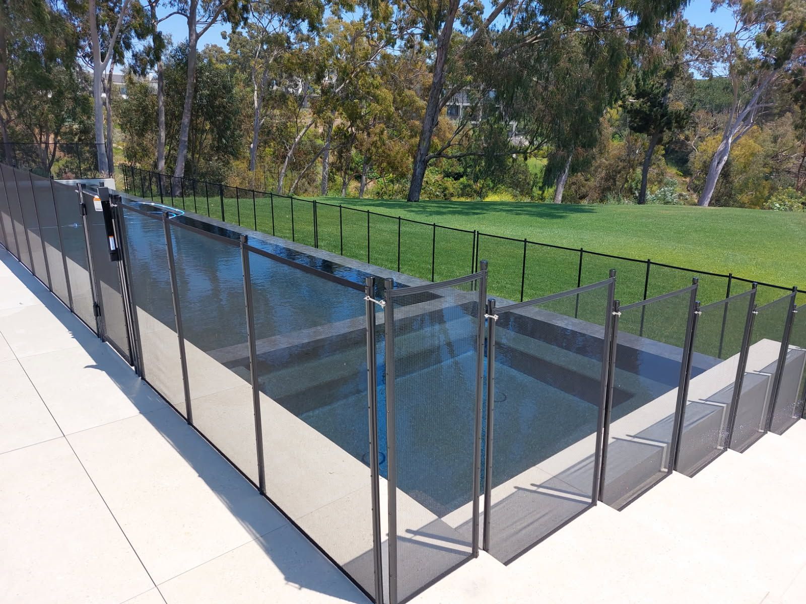 Image of a home in California's backyard pool with a black mesh pool fence around it.