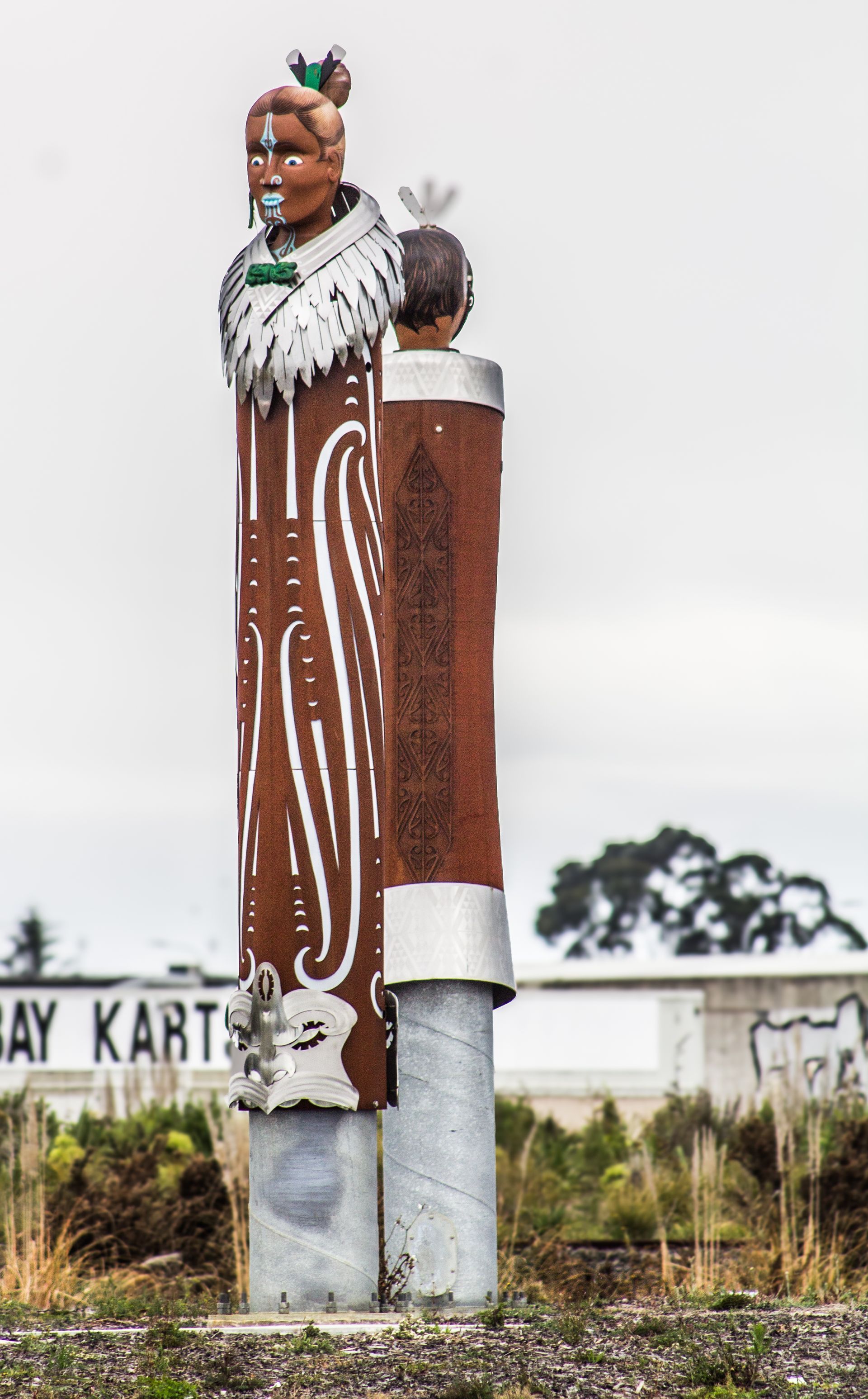 A statue of a man standing next to a sign that says way kart