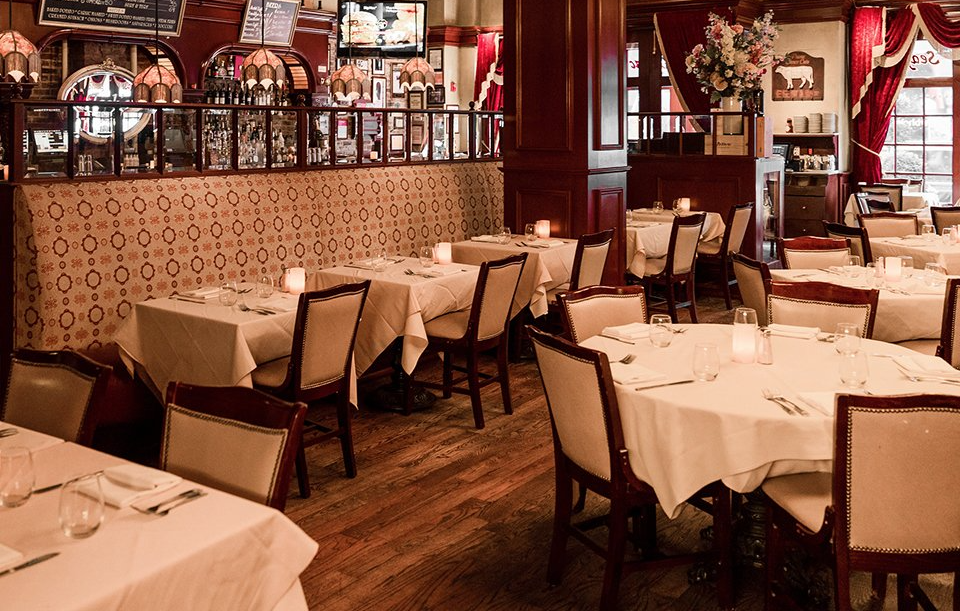 A restaurant filled with tables and chairs with candles on them