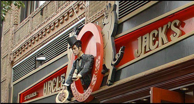 A sign for jack 's steaks has a man in a top hat on it