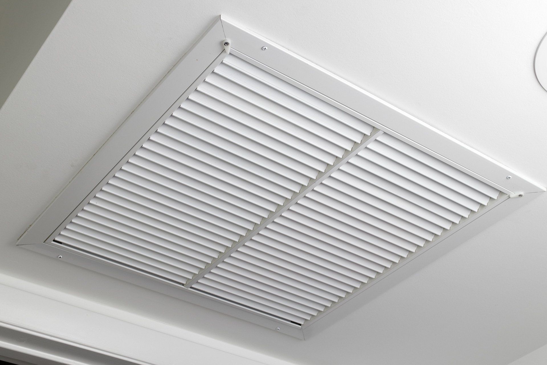 White rectangular ceiling vent with horizontal slats.