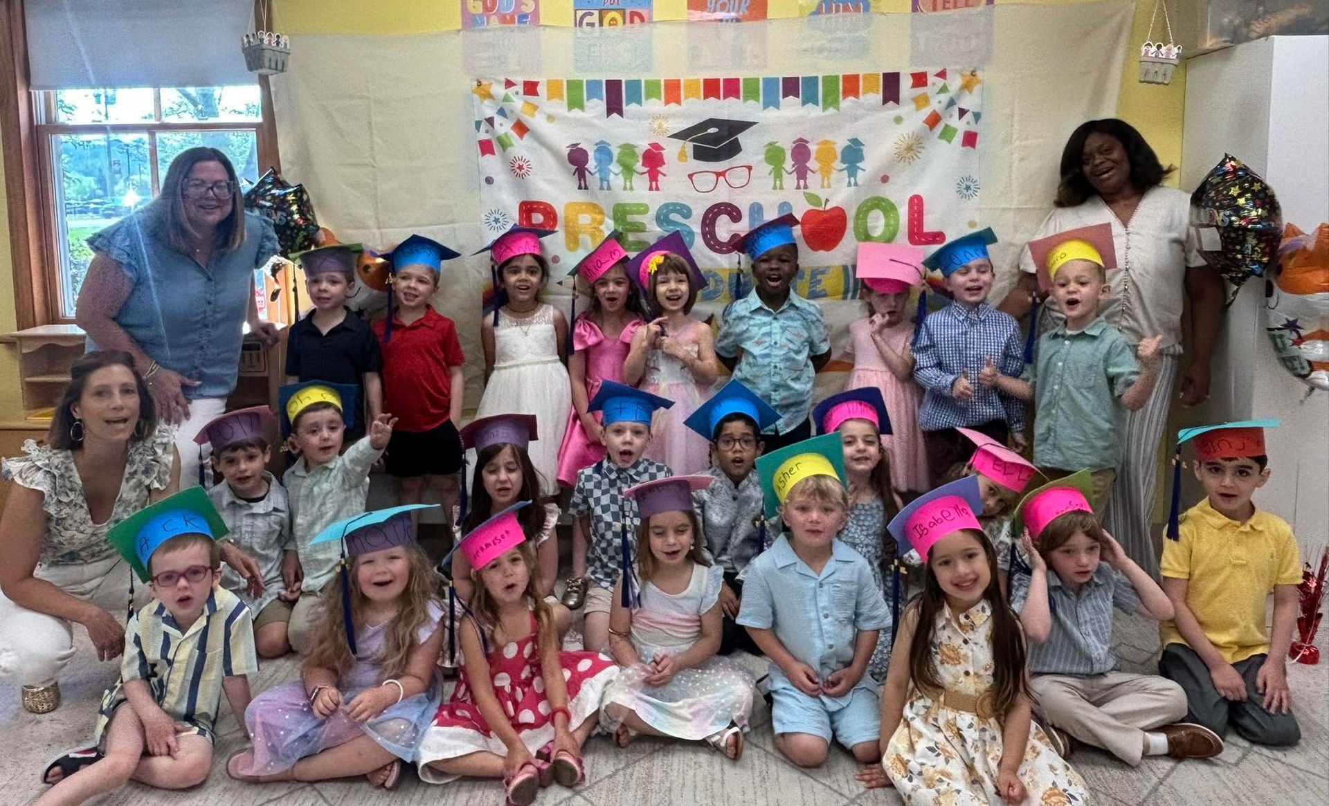 Faith Lutheran Preschool Graduation Class of 2026 picturing teachers and students in graduation hats