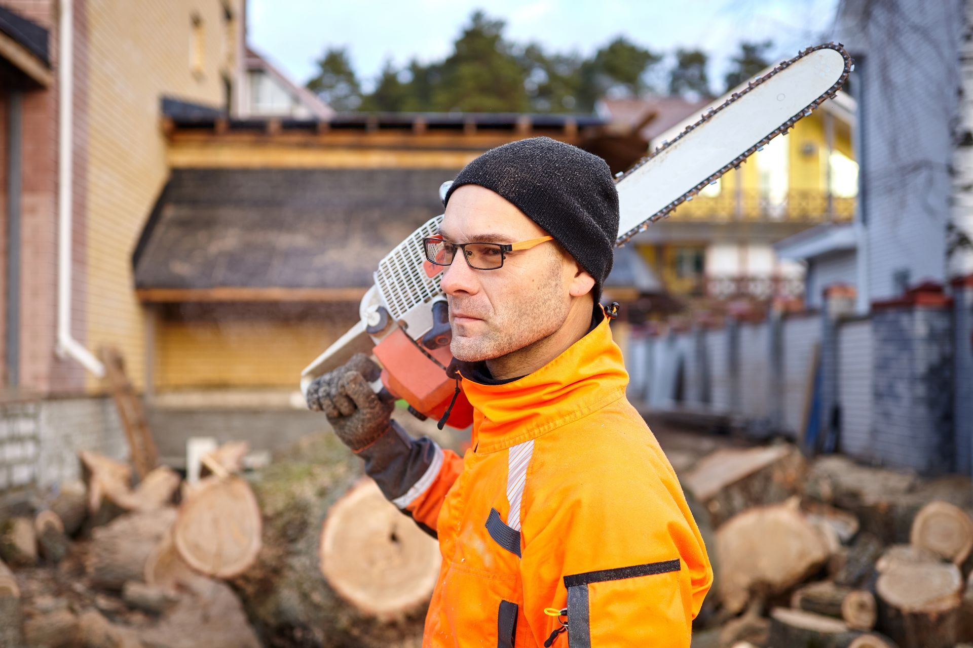 a man is cutting a tree branch with a chainsaw .