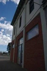A large brick building with a lot of windows and a blue sky in the background.
