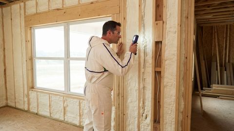 Temple spray foam technician inspecting completed insulation work