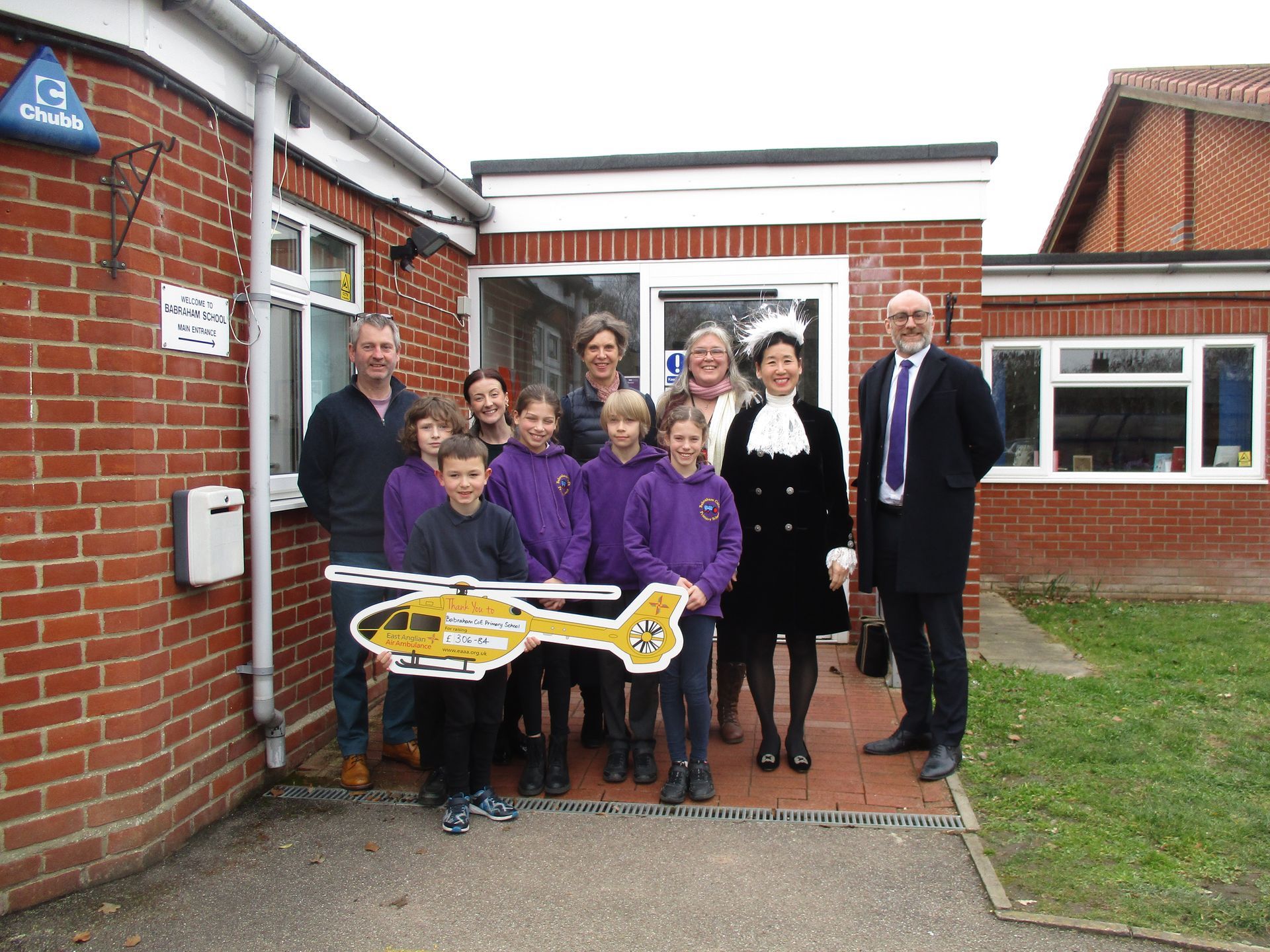 Babraham CofE Primary School present money they've raised to East Anglian Air Ambulance