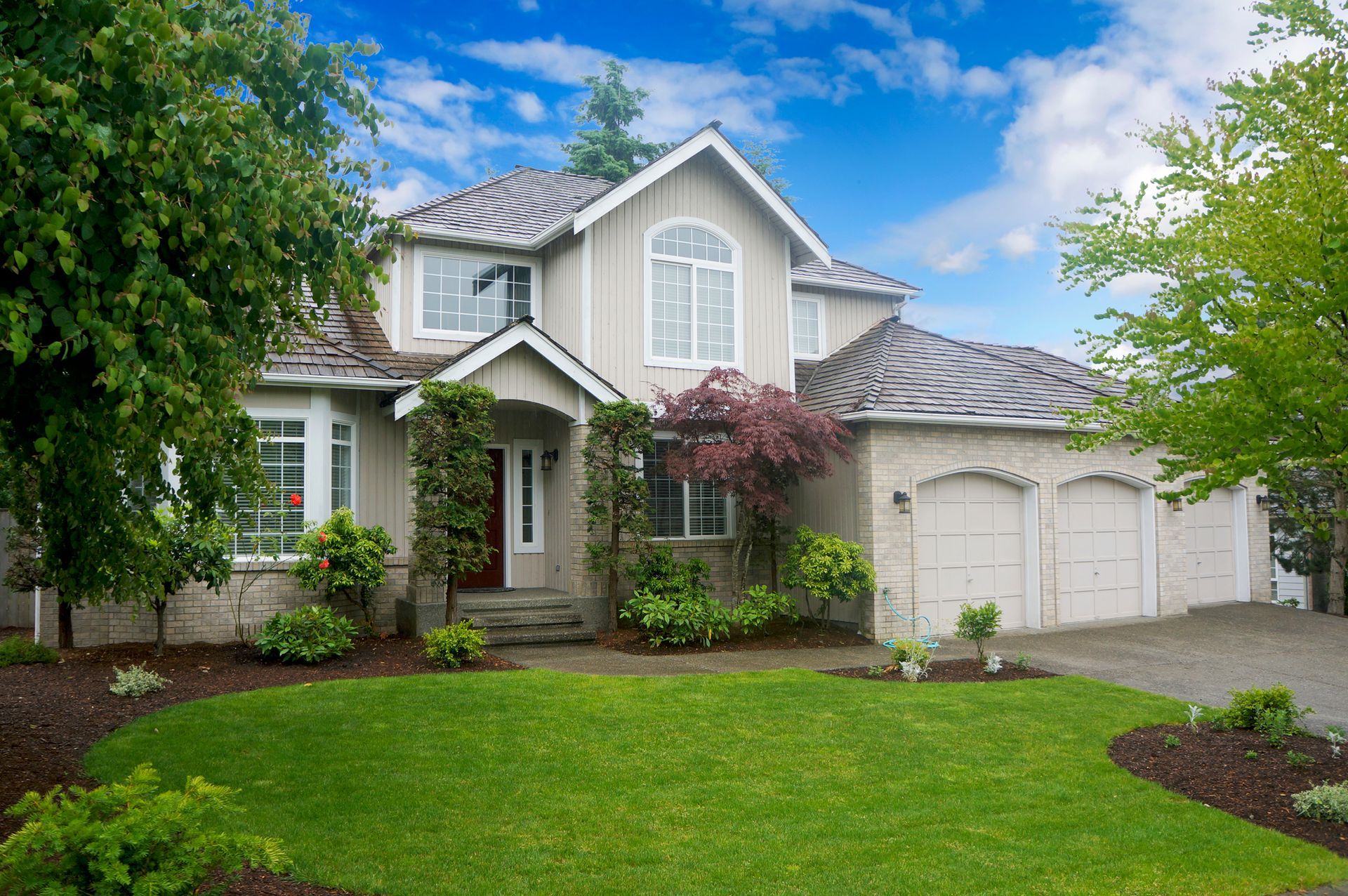 a large house with a lush green lawn in front of it