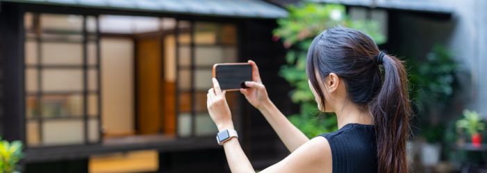 a woman taking a photo on her phone of a building