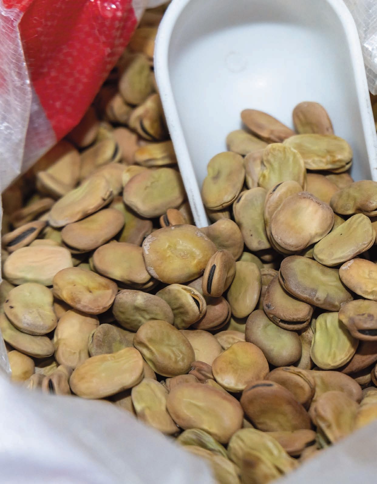 Un sacchetto di fagioli con dentro un cucchiaio bianco