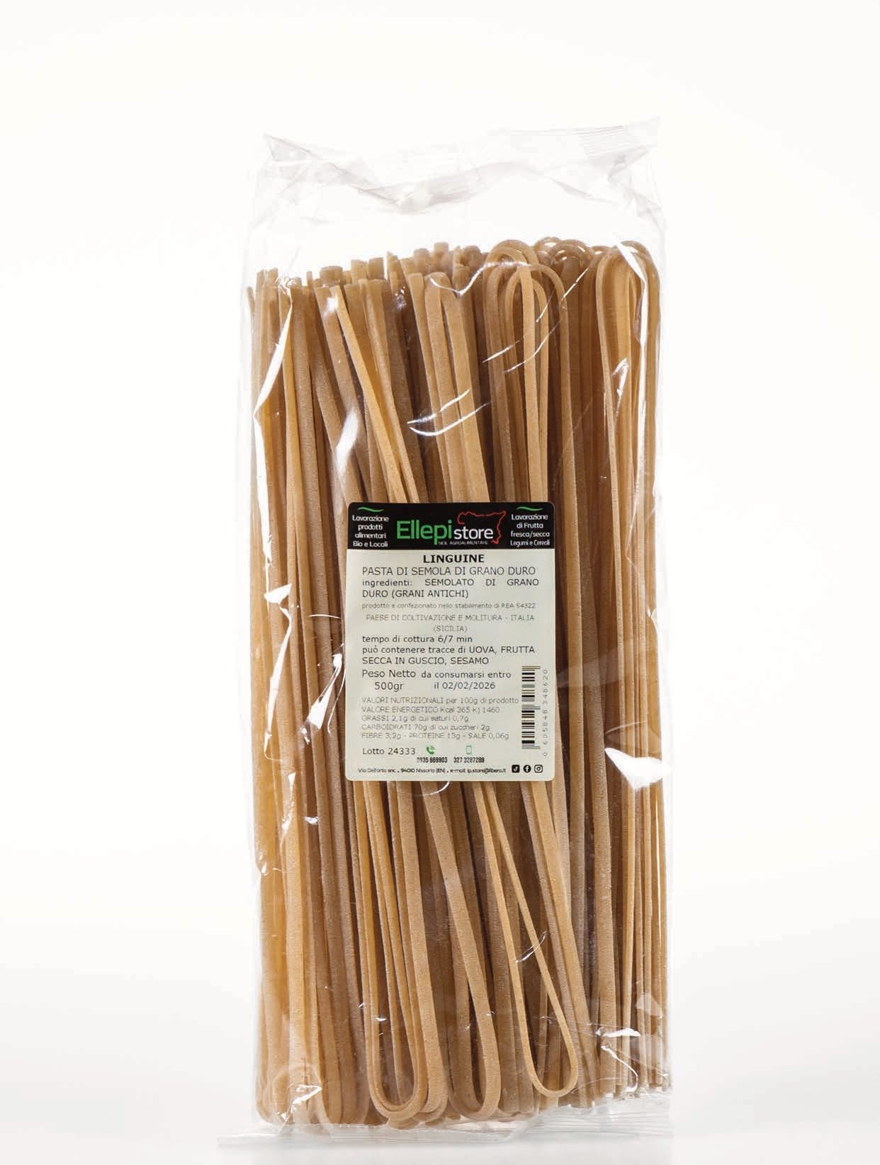 Un sacchetto di pasta è appoggiato su un tavolo bianco.
