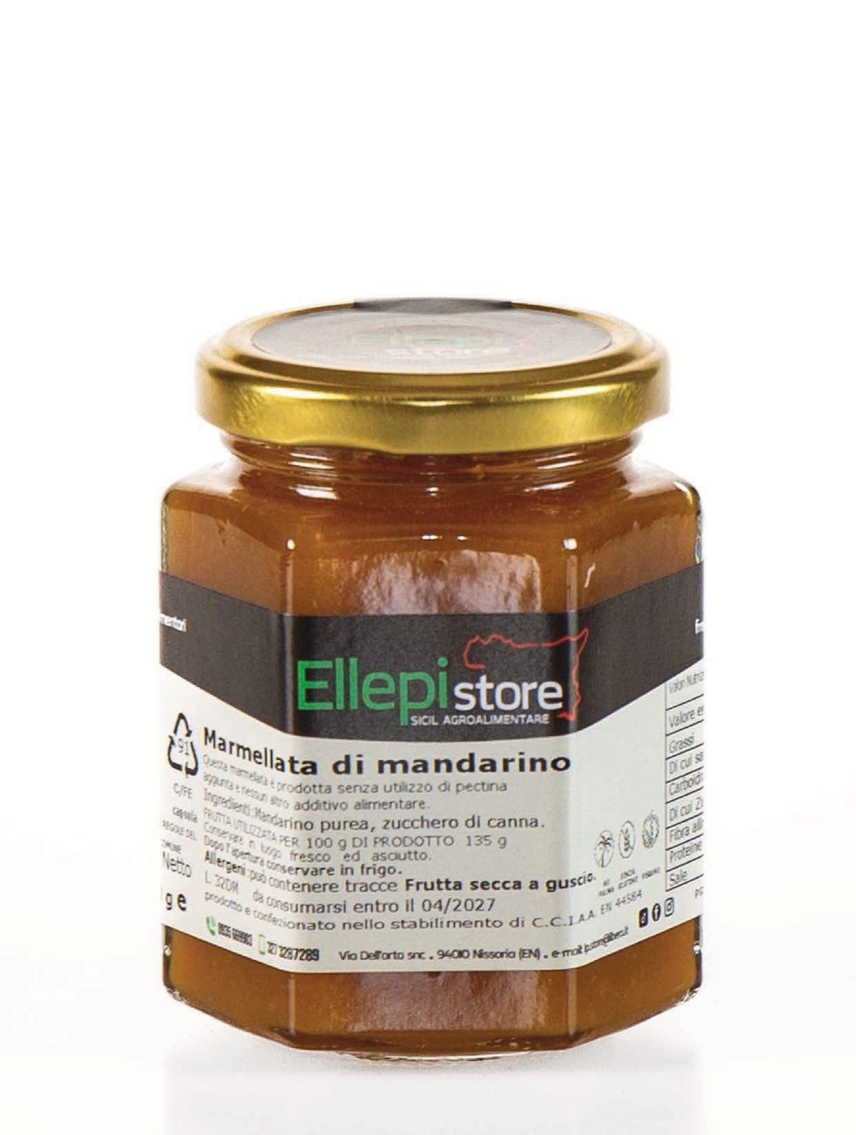 Un barattolo di marmellata è appoggiato su una superficie bianca.