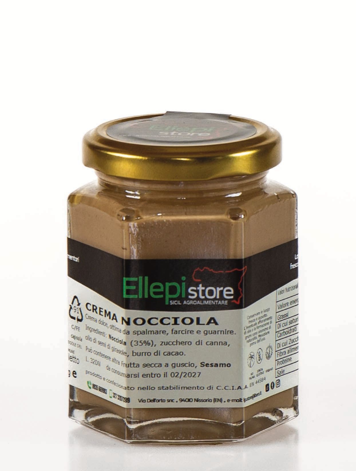 Un barattolo di crema alla nocciola è appoggiato su una superficie bianca.