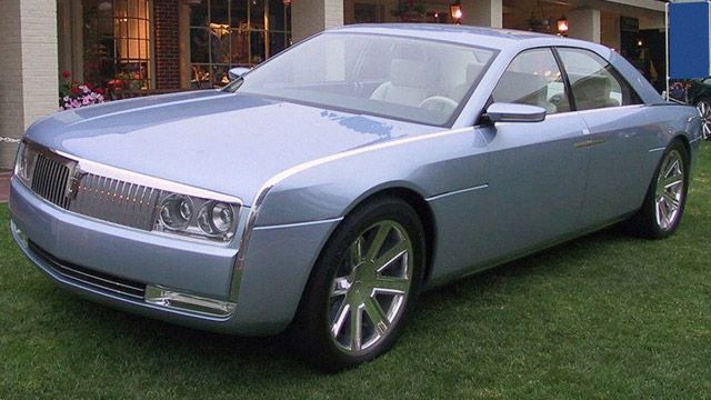 Silver Cadillac concept car parked on grass in front of a building