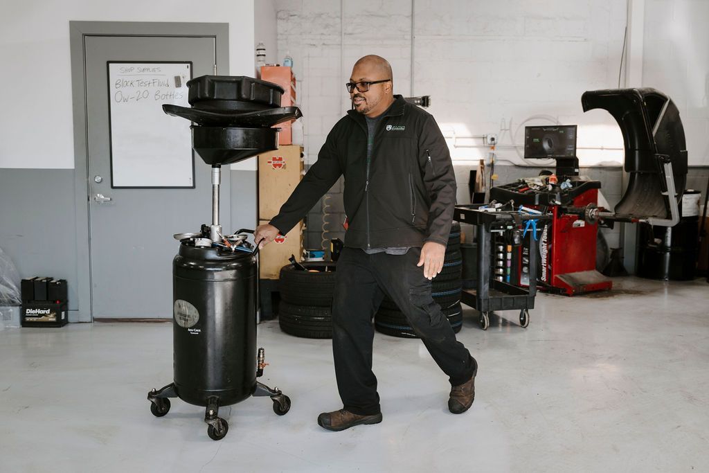 Man walking beside a black rolling smoker in a garage workshop
