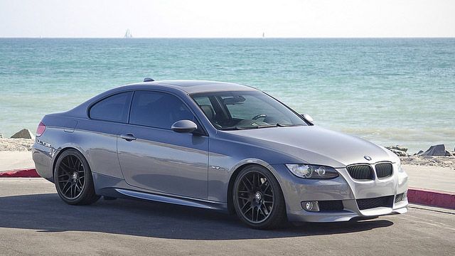 Silver BMW coupe parked by the ocean on a sunny day