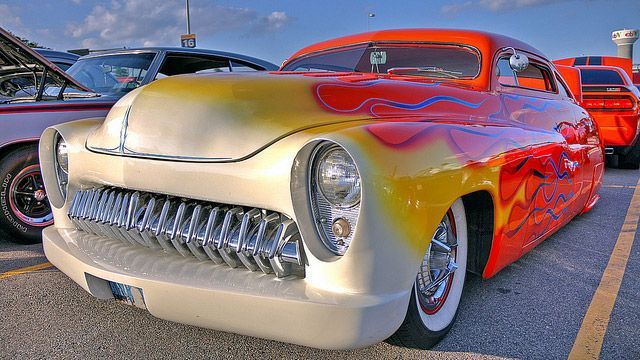 Vintage cream and red custom hot rod parked in a lot at sunset