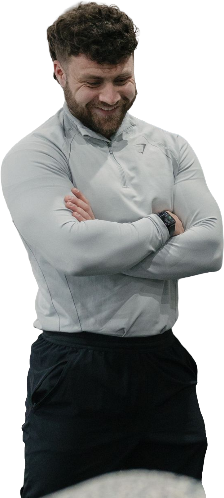 A shirtless man in shorts is standing with his hands on his hips.