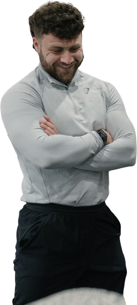 A shirtless man in shorts is standing with his hands on his hips.