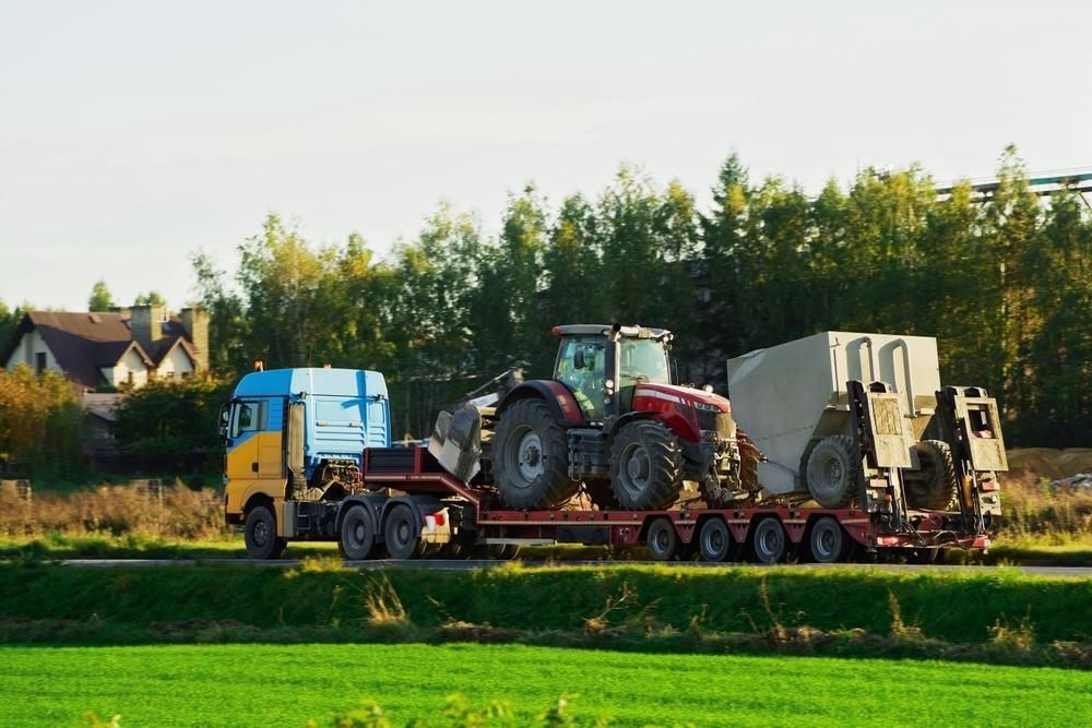 A sEmi Truck is Carrying a Tractor on a Trailer — Bulahdelah Towing In Karuah, NSW