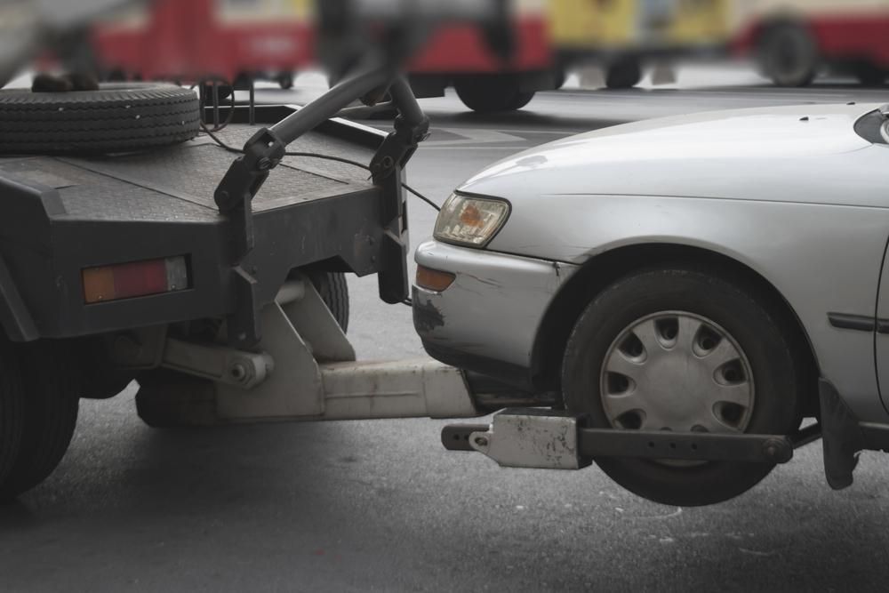 A Car is Being Towed by a Tow Truck — Bulahdelah Towing In Stroud, NSW