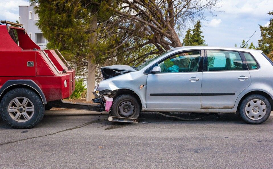A Tow Truck is Towing a Damaged Car on the Side of the Road — Bulahdelah Towing In Hawks Nest, NSW