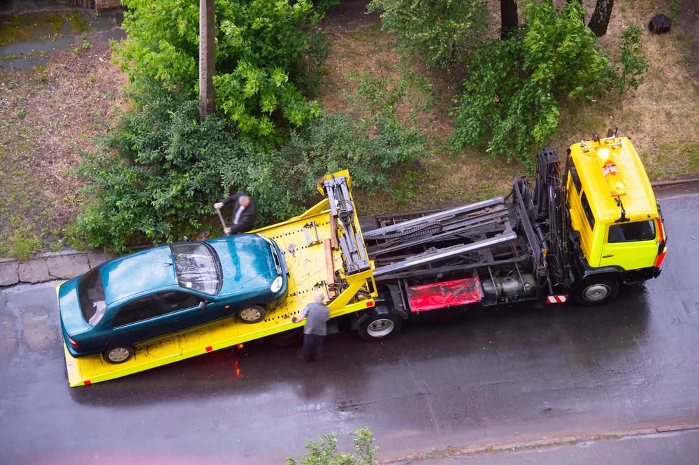 A Tow Truck is Towing a Car on a Flatbed Trailer — Bulahdelah Towing In Stroud, NSW