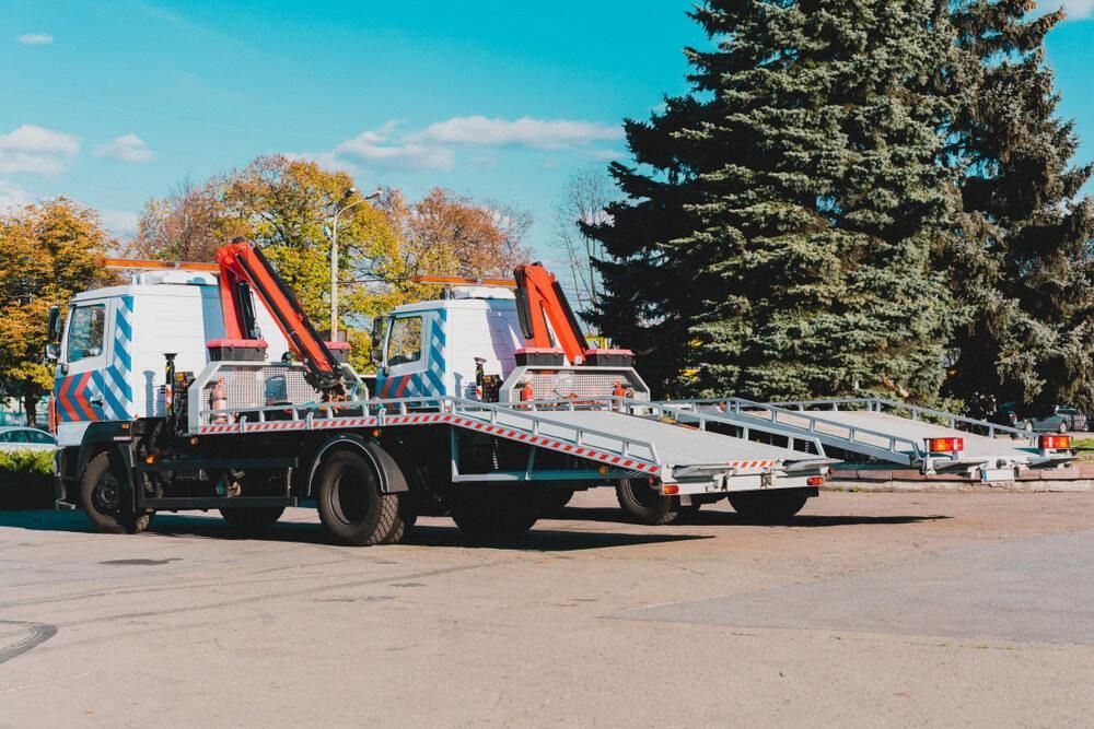 Two Tow Trucks Are Parked Next to Each Other in a Parking Lot — Bulahdelah Towing In Bulahdelah, NSW