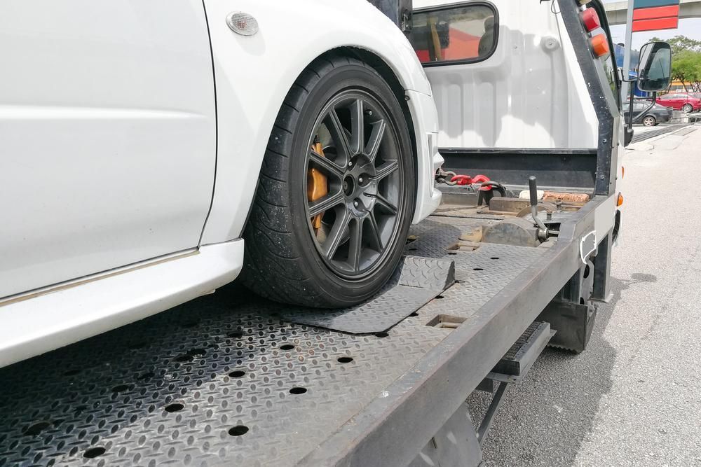 A White Car is Being Towed by a Tow Truck — Bulahdelah Towing In Stroud, NSW