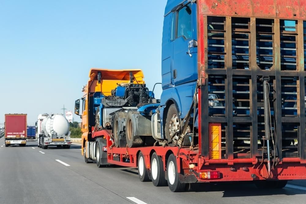 A Truck With a Trailer is Driving Down a Highway — Bulahdelah Towing In Karuah, NSW