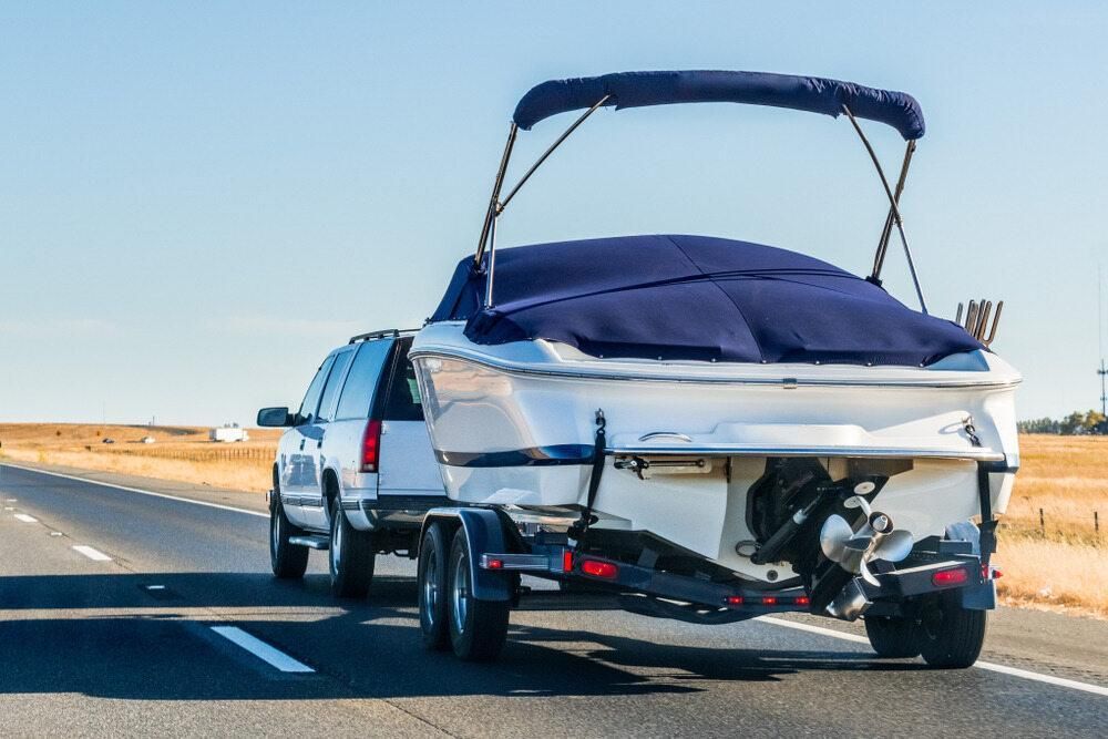 A Truck is Towing a Boat Down a Highway — Bulahdelah Towing In Tea Gardens, NSW