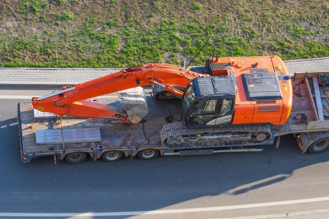 An Aerial View of a Truck Carrying an Excavator on a Highway — Bulahdelah Towing In Tea Gardens, NSW