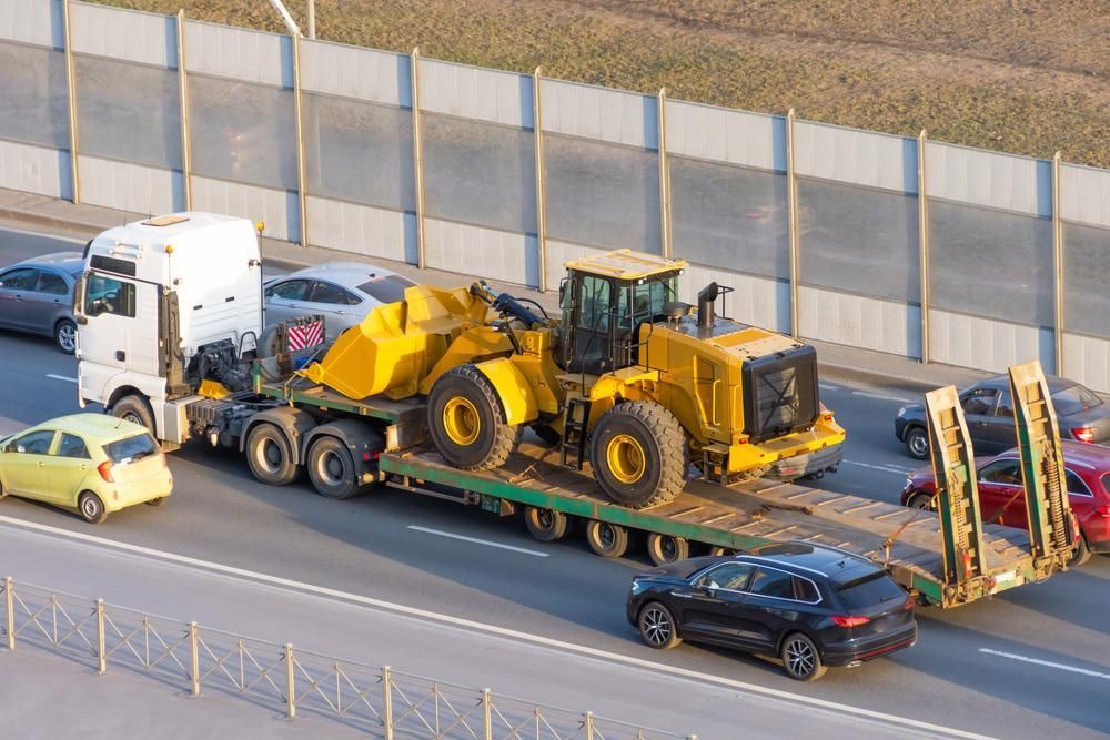 A Truck is Carrying a Bulldozer on a Trailer on a Highway — Bulahdelah Towing In Stroud, NSW