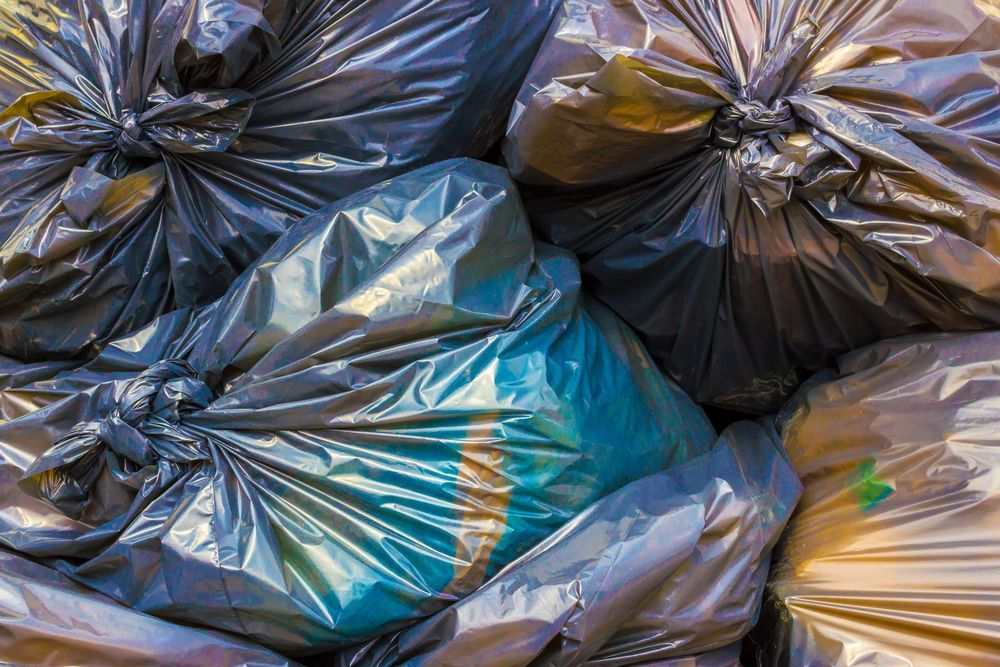 Pile of Black and Tan Garbage Bags Tied — Tamworth Skips and Rubbish Removal in Kootingal, NSW