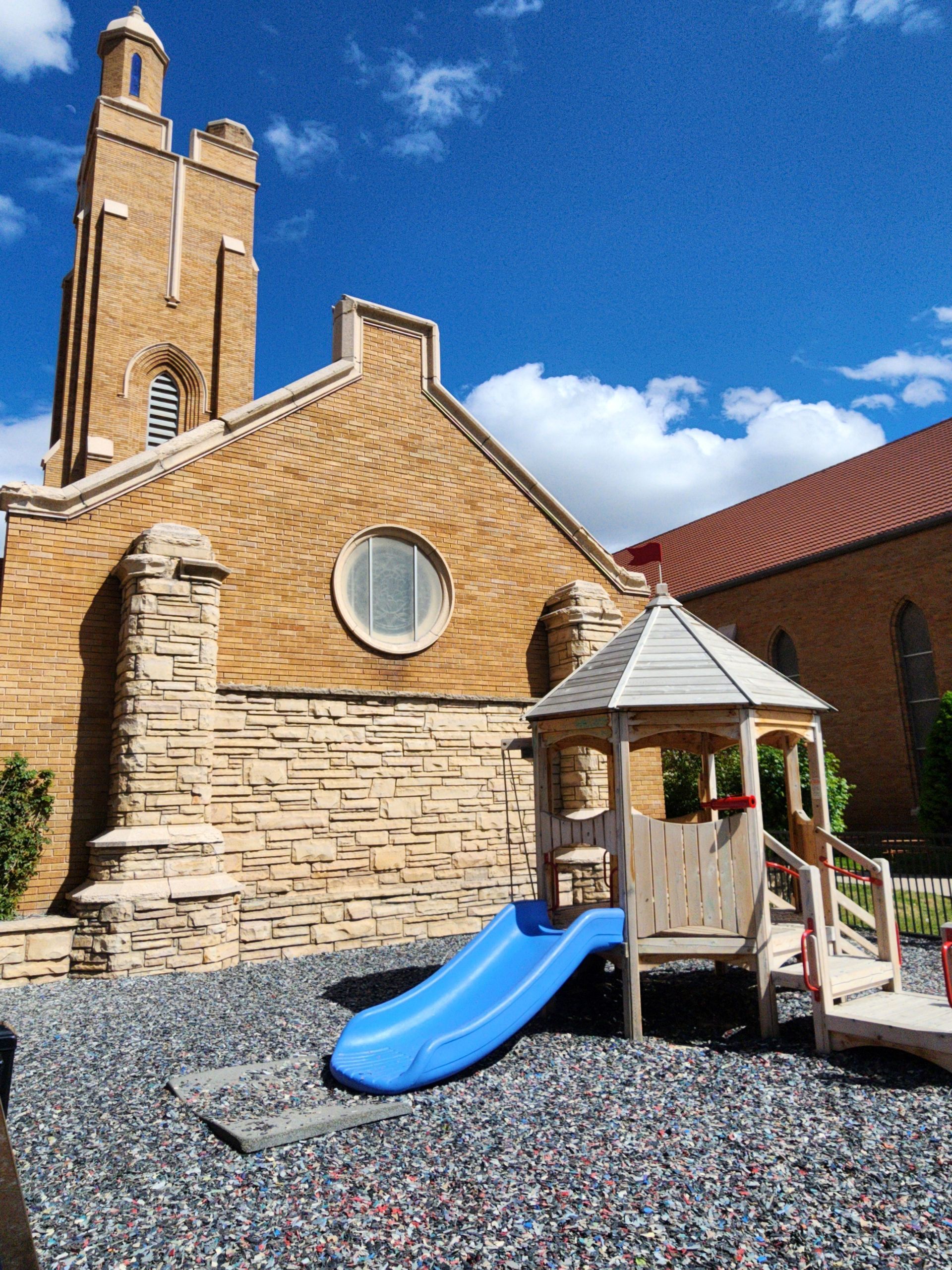 Children playing outdoors at a preschool; riding trikes on a track, building blocks.
