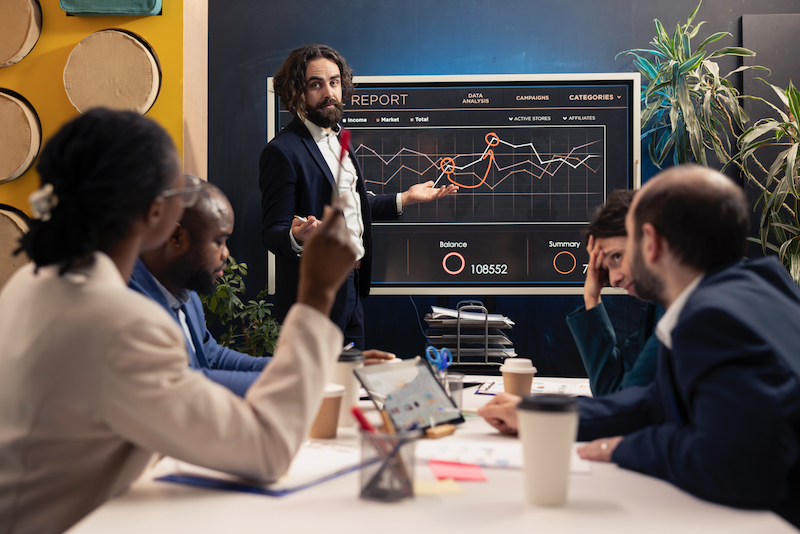 A man is giving a presentation to a group of people in a conference room.