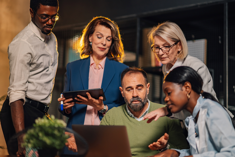 A group of people are looking at a laptop computer.