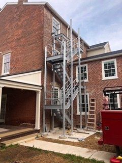 Exterior view of a brick building with a newly installed metal fire escape.