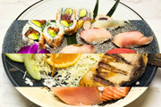 Assorted sushi and sashimi on a white plate with avocado, orange, and shredded garnish