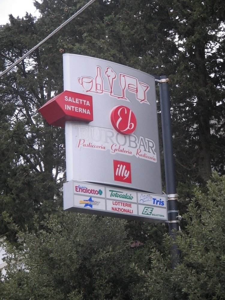 Cartello per "El Eurobar" con altri loghi aziendali sotto. Rosso, argento e bianco.