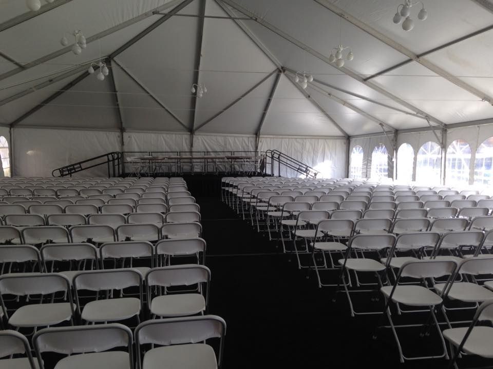 Rows of White Folding Chairs Under a White Tent
