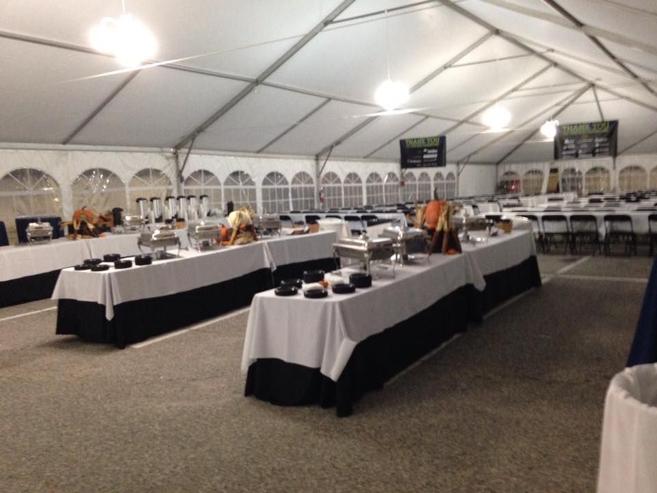 A Large Tent With Tables and Chairs Set Up for a Buffet