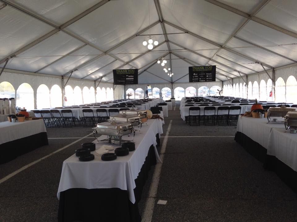 A Large White Tent Filled With Tables and Chairs