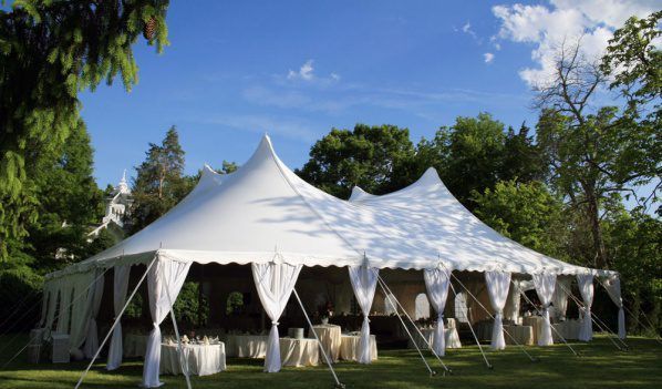 A Large White Tent With Tables and Chairs Underneath It