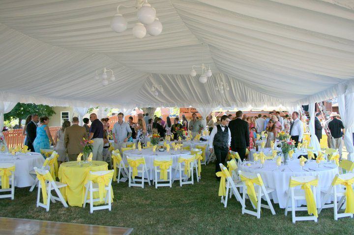 Large Tent With Tables and Chairs Set Up for a Wedding Reception.