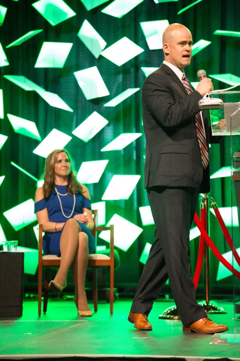 Ann watching tye speak at event on stage