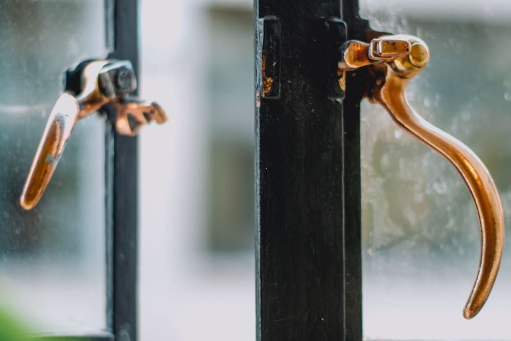 A close up of a window with two handles on it.