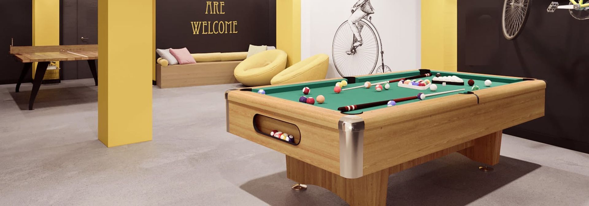 A pool table in a room with a bicycle on the wall.